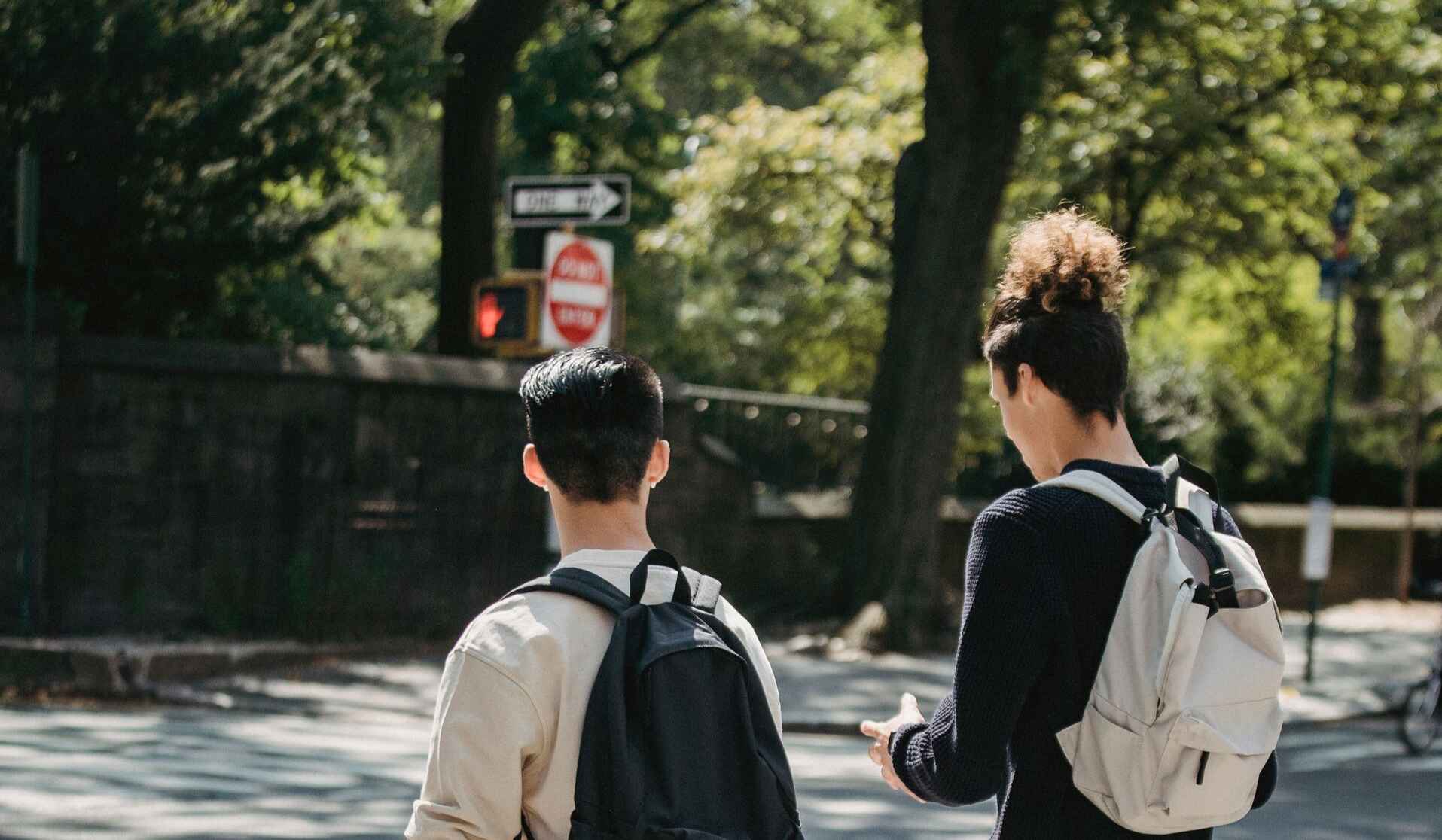 Two young men walking across the street