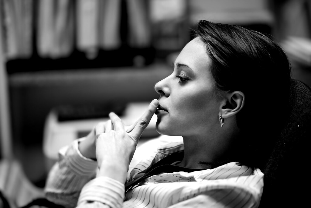 woman in business attire leans back in her chair thinking