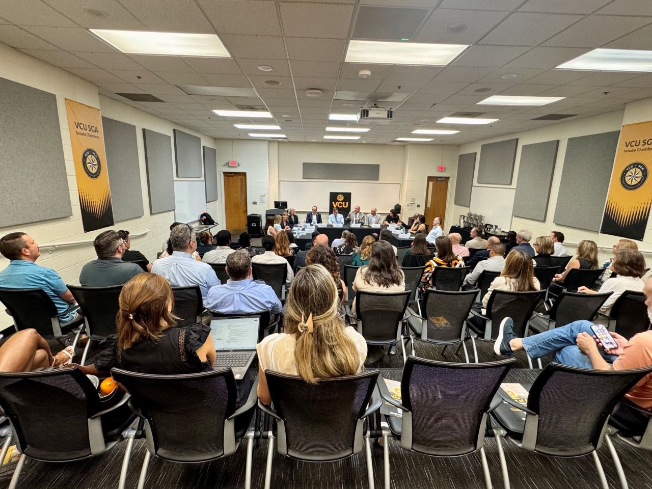 Sen. Mark Warner speaks to a full room of attendees seated in the VCU Student Government Association Senate Chambers.