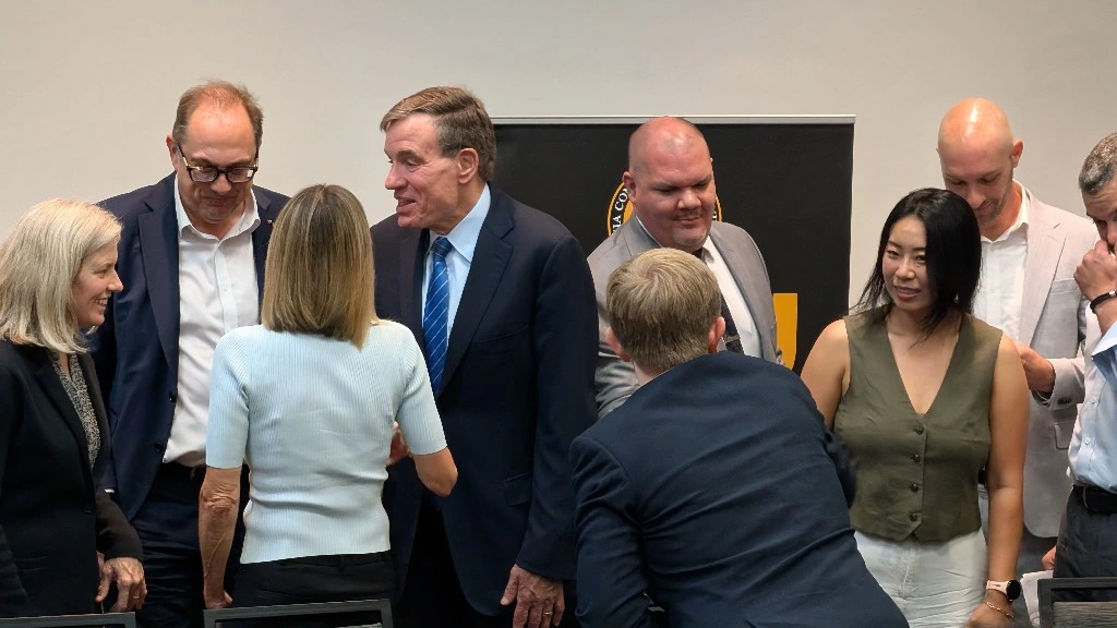 Sen. Mark Warner shakes hands with an attendee after the AI Ready RVA roundtable.