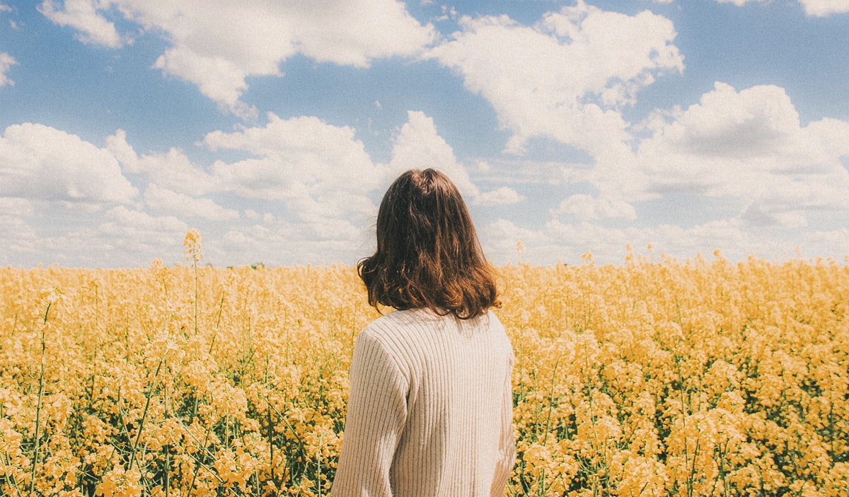 Woman enjoying springtime in a field of yellow flowers, allergy-free